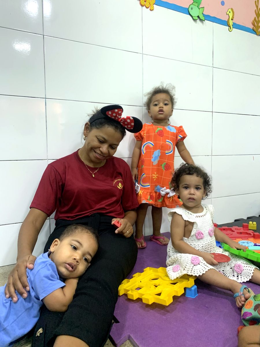 Professora acolhendo as crianças no Colégio Nena Kids